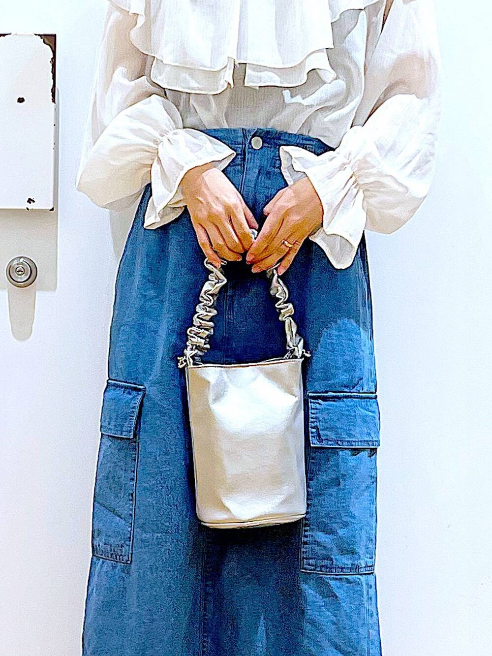 その他のショルダーバッグ、その他のパンプス、ブルー系のデニムスカートを着用したレディースの春コーディネートの9枚目の写真