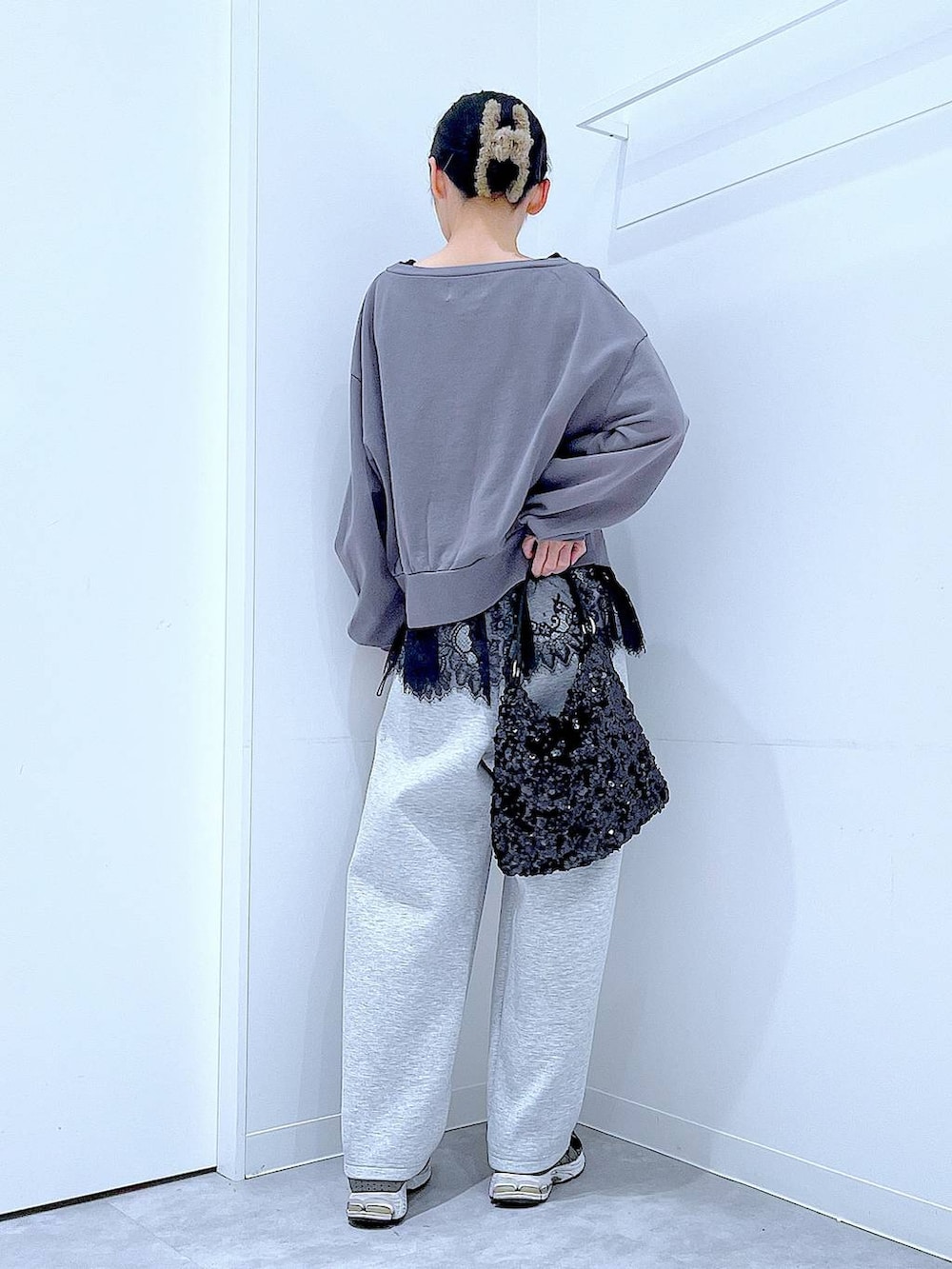 グレー系のスウェット、ブラック系のショルダーバッグ、ブラック系のタンクトップを着用したレディースの春コーディネートの5枚目の写真