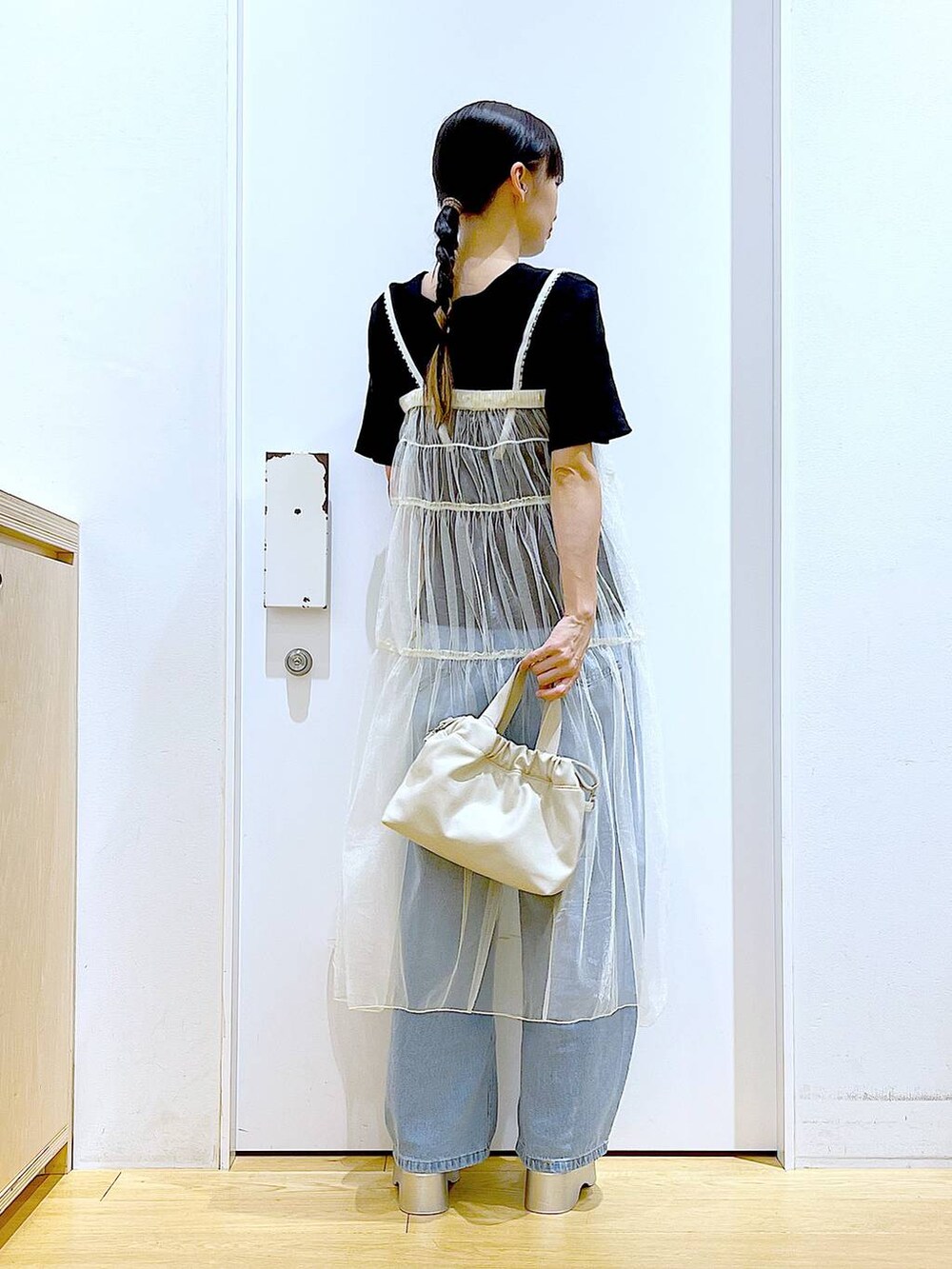 ブルー系のデニムパンツ、ホワイト系のショルダーバッグ、ブラック系のTシャツ/カットソーを着用したレディースの夏コーディネートの5枚目の写真