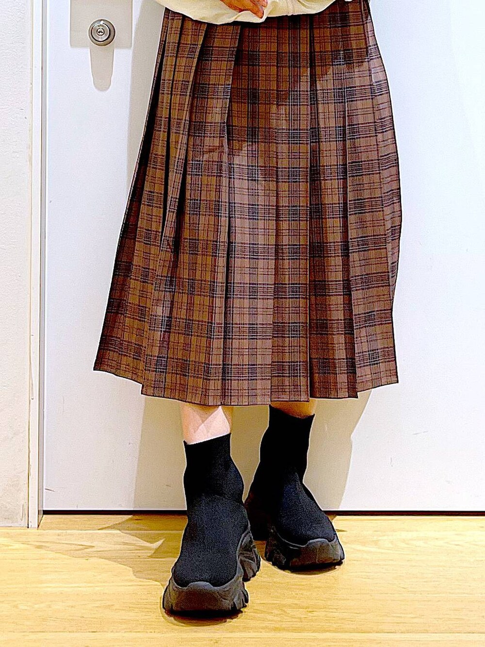 ホワイト系のショルダーバッグ、ベージュ系のブルゾン、ブラック系のブーツを着用したレディースの秋コーディネートの8枚目の写真