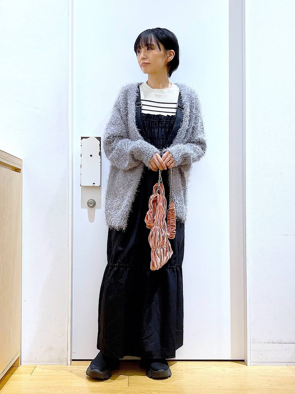 ホワイト系のニット/セーター、ピンク系のショルダーバッグ、グレー系のカーディガン/ボレロを着用したレディースの冬コーディネートの2枚目の写真