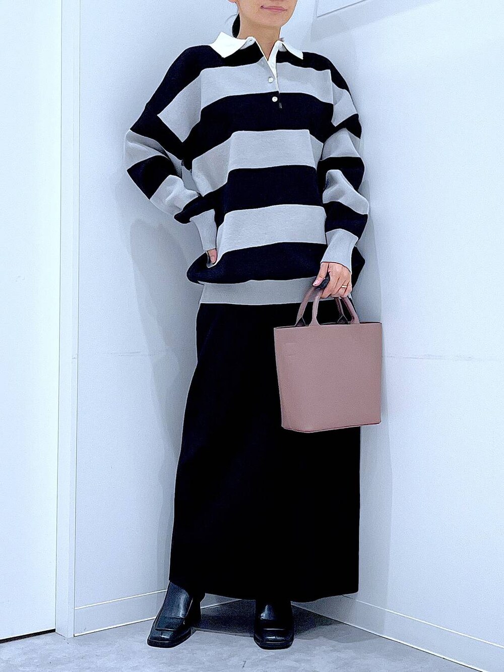 ブラック系のショルダーバッグ、ブラック系のニット/セーター、ブラック系のブーツを着用したレディースの秋コーディネートの6枚目の写真