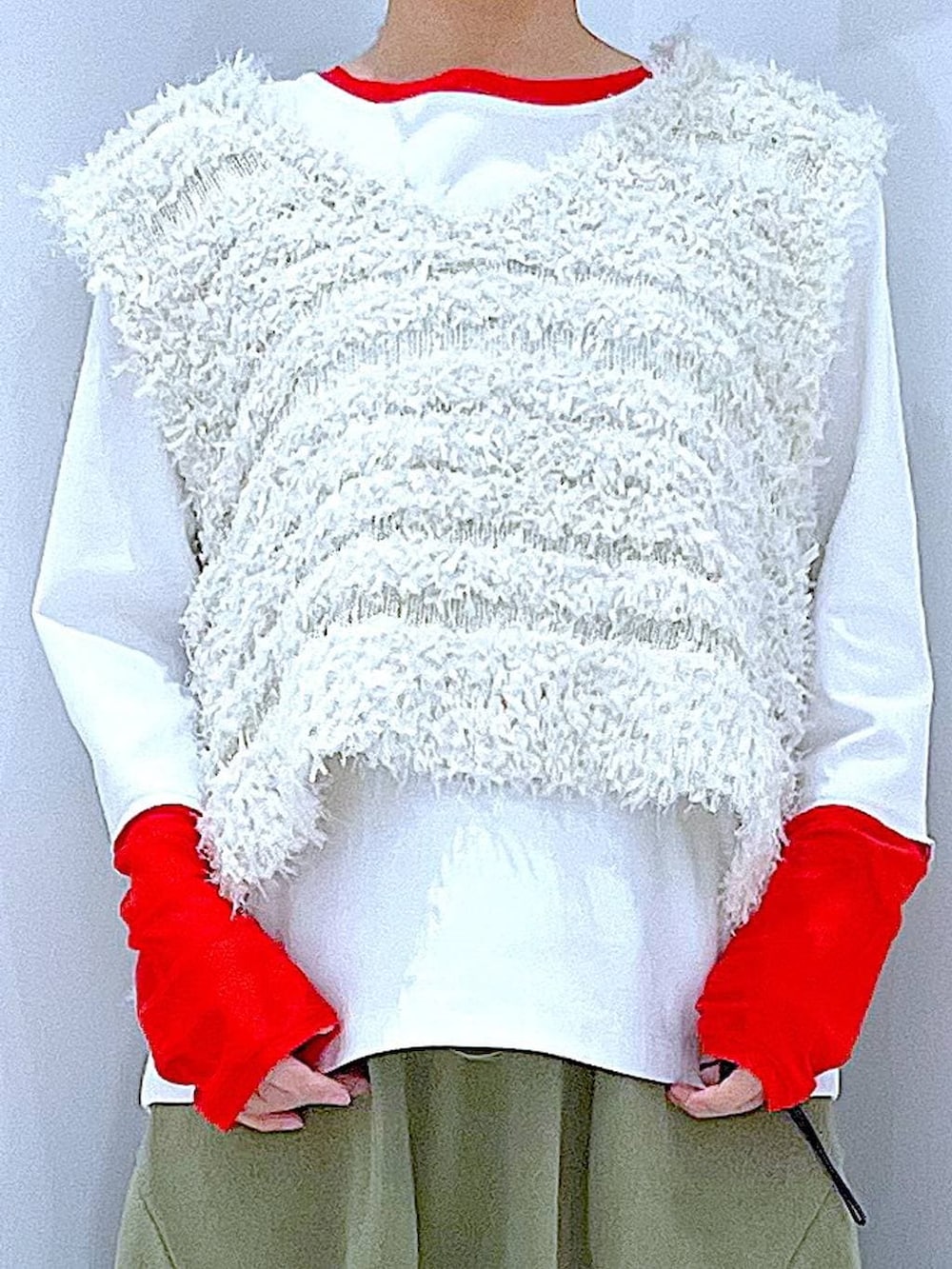 グリーン系のスカート、ホワイト系のTシャツ/カットソー、ベージュ系のベストを着用したレディースの冬コーディネートの7枚目の写真