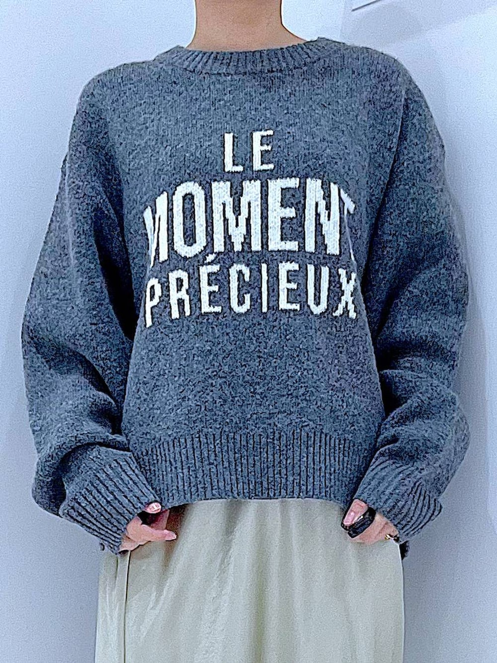 ブラック系のブーツ、グレー系のニット/セーター、ホワイト系のショルダーバッグを着用したレディースの冬コーディネートの7枚目の写真