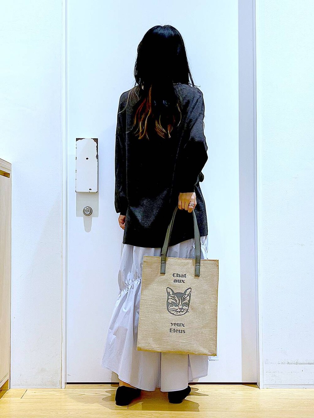 ブルー系のスカート、グレー系のカーディガン/ボレロ、ブラック系のパンプスを着用したレディースの春コーディネートの5枚目の写真