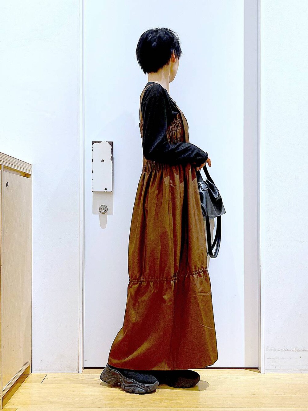 ブラック系のブーツ、ブラウン系のワンピース、ブラック系のショルダーバッグを着用したレディースの冬コーディネートの4枚目の写真