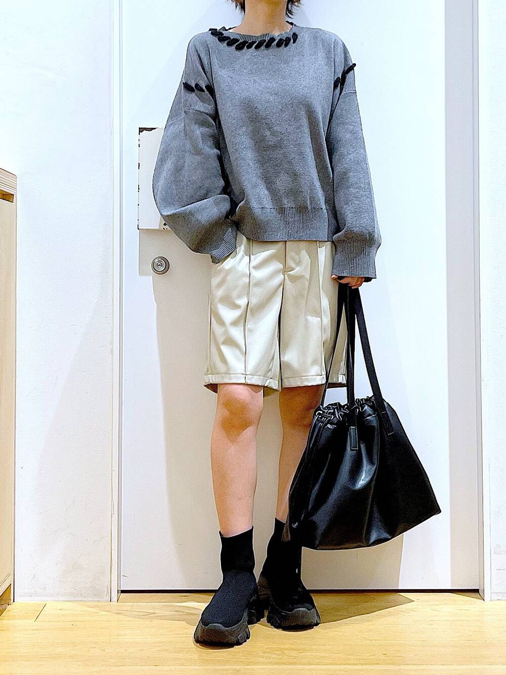 ブラック系のトートバッグ、ブラック系のブーツ、グレー系のニット/セーターを着用したレディースの冬コーディネートの6枚目の写真