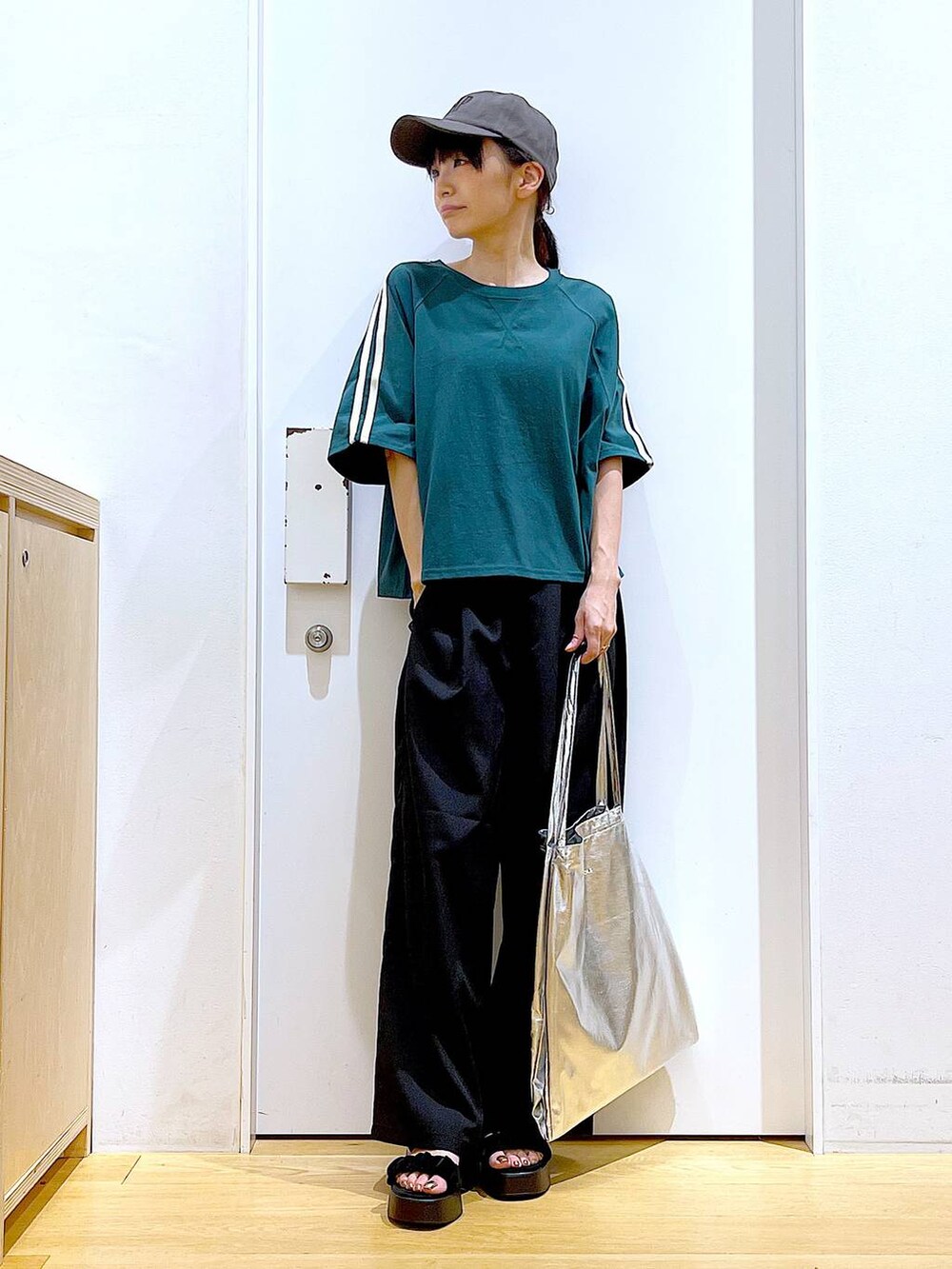 シルバー系のトートバッグ、ブラック系のサンダル、ブラック系のその他パンツを着用したレディースの夏コーディネートの2枚目の写真