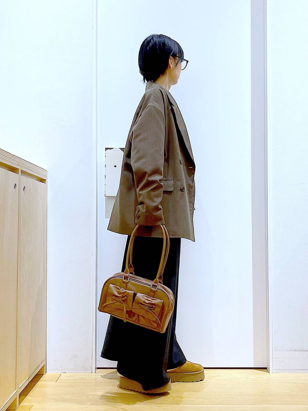 ベージュ系のスリッポン、ブラウン系のハンドバッグ、ブラウン系のテーラードジャケットを着用したレディースの秋コーディネートの4枚目の写真