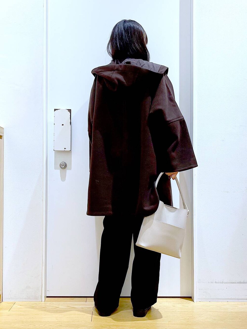 ブラウン系のその他アウター、グレー系のショルダーバッグ、ブラック系のブーツを着用したレディースの冬コーディネートの5枚目の写真