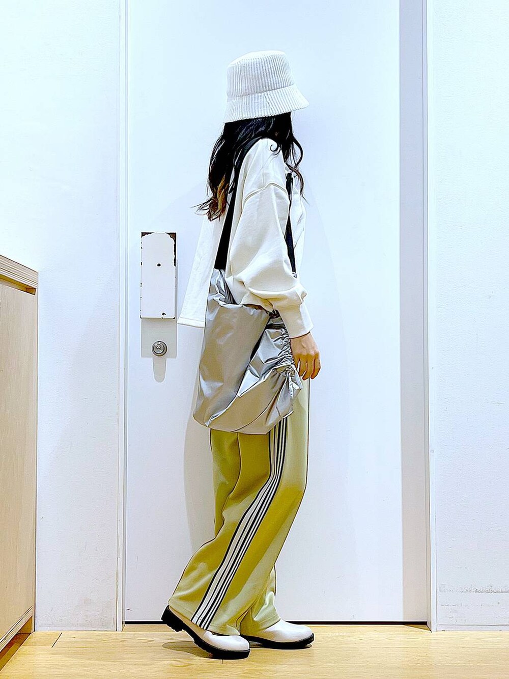 ホワイト系のスウェット、ベージュ系のブーツ、シルバー系のショルダーバッグを着用したレディースの春コーディネートの4枚目の写真