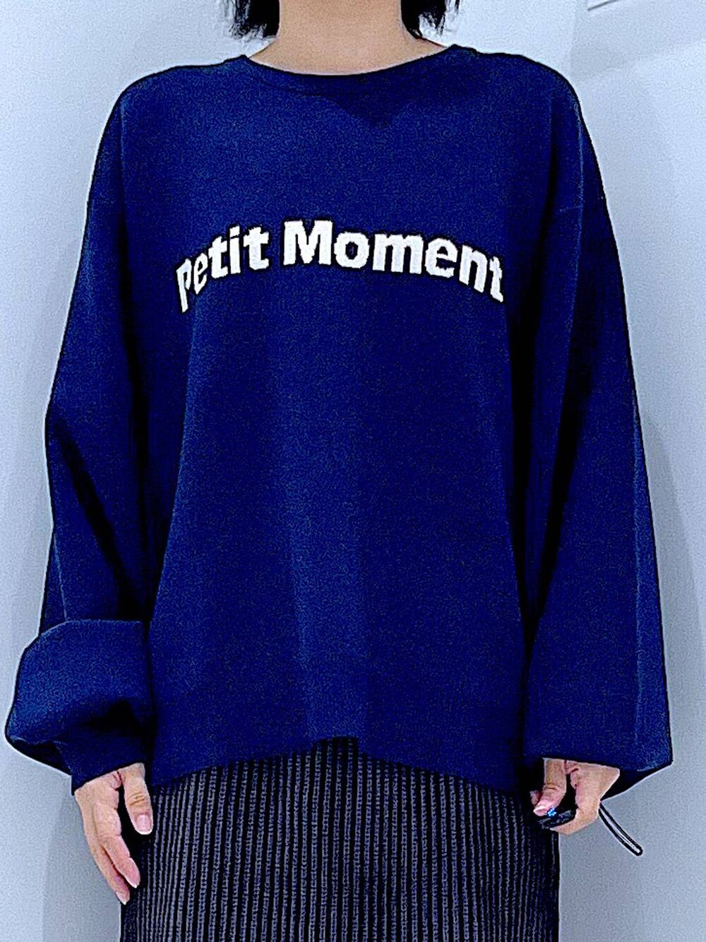 ブラック系のスカート、ブラック系のショルダーバッグ、ブラック系のブーツを着用したレディースの冬コーディネートの7枚目の写真