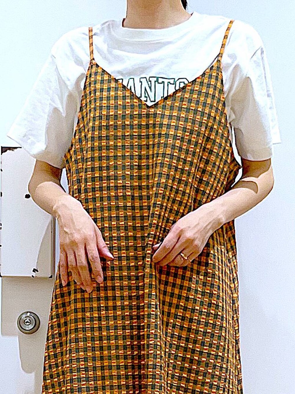 オレンジ系のワンピース、ブラック系のバックパック/リュック、ブラック系のパンプスを着用したレディースの春コーディネートの7枚目の写真