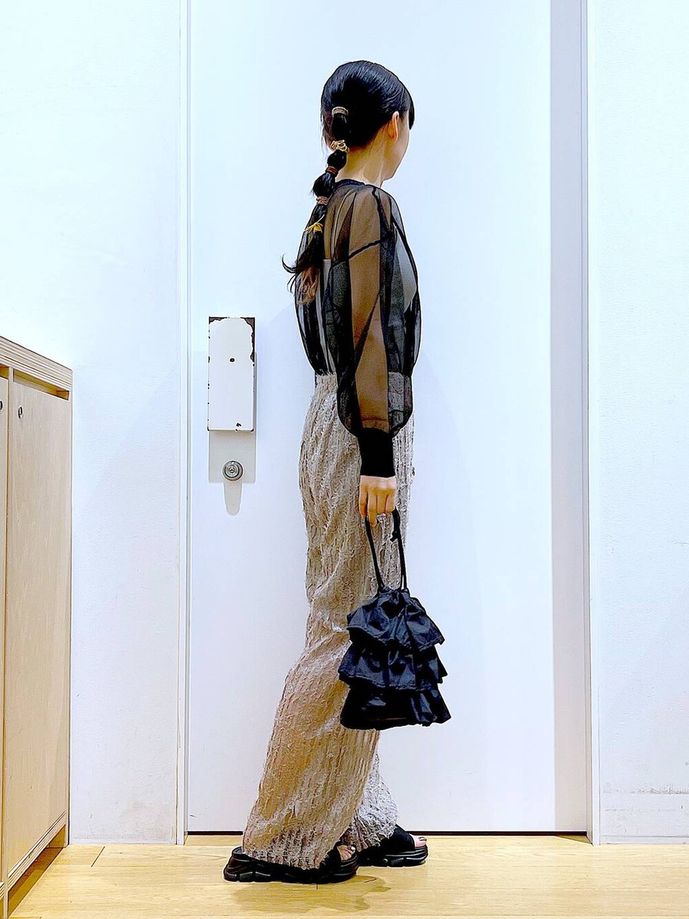 ブラック系のショルダーバッグ、ブラック系のサンダル、ブラック系のカーディガン/ボレロを着用したレディースの夏コーディネートの4枚目の写真