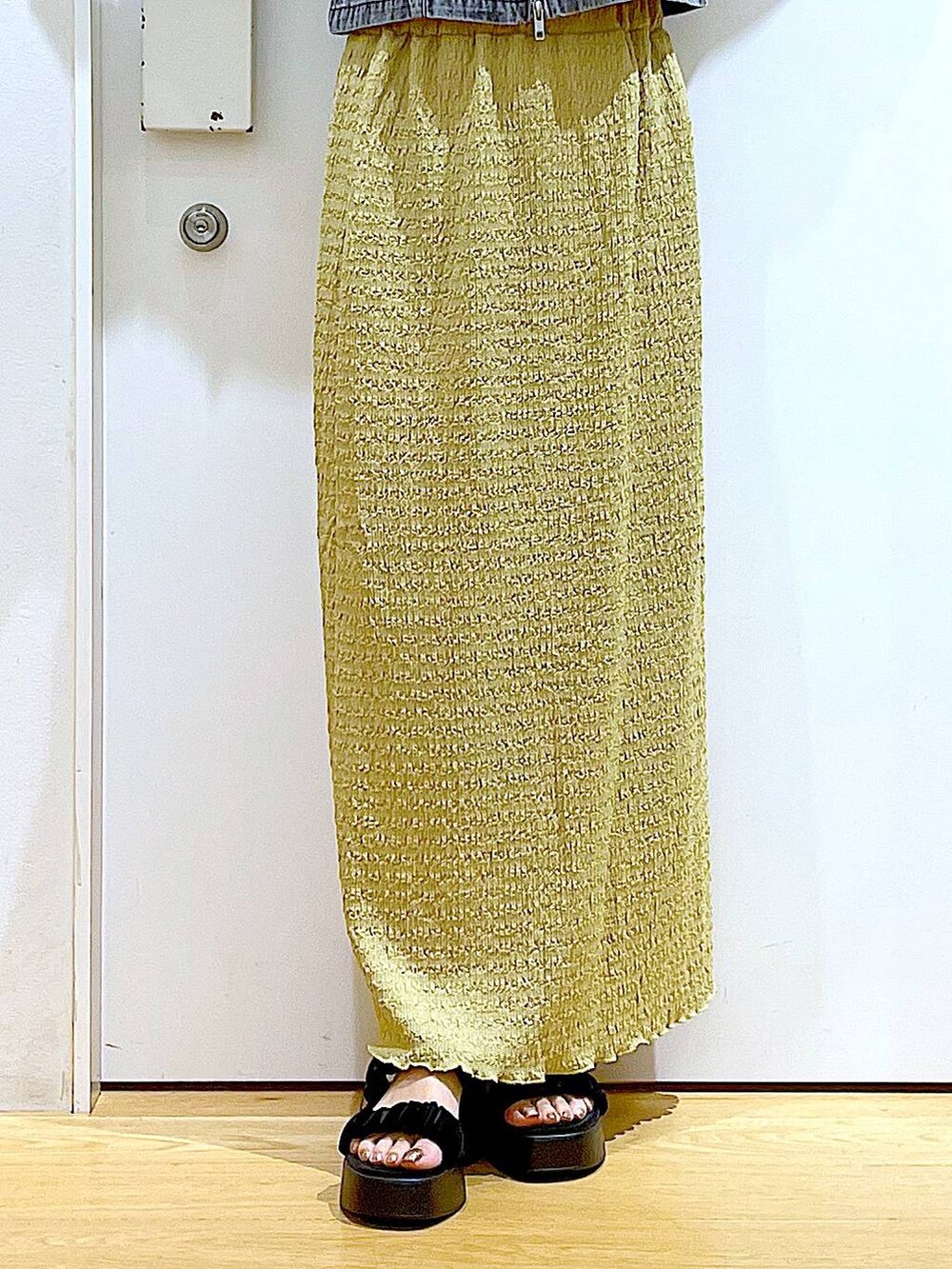 シルバー系のショルダーバッグ、グリーン系のスカート、ブラック系のTシャツ/カットソーを着用したレディースの夏コーディネートの8枚目の写真