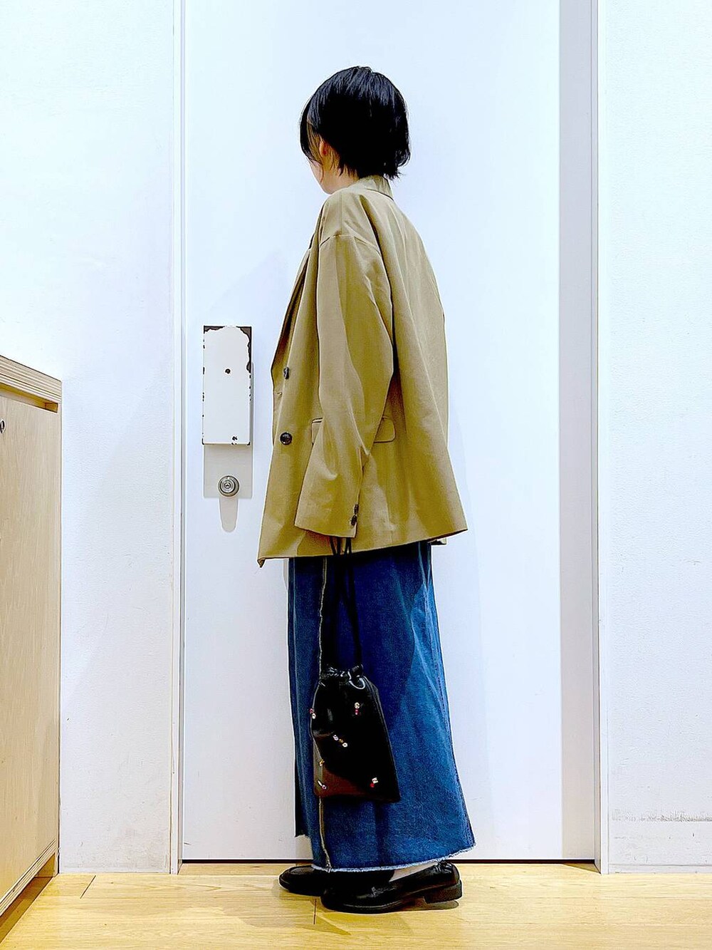 ブラック系のショルダーバッグ、ブラック系のローファー、ブラック系のTシャツ/カットソーを着用したレディースの秋コーディネートの3枚目の写真