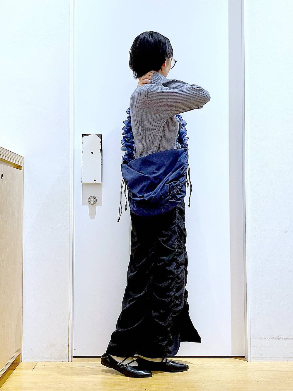 ブラック系のパンプス、ブルー系のショルダーバッグ、グレー系のカーディガン/ボレロを着用したレディースの秋コーディネートの4枚目の写真