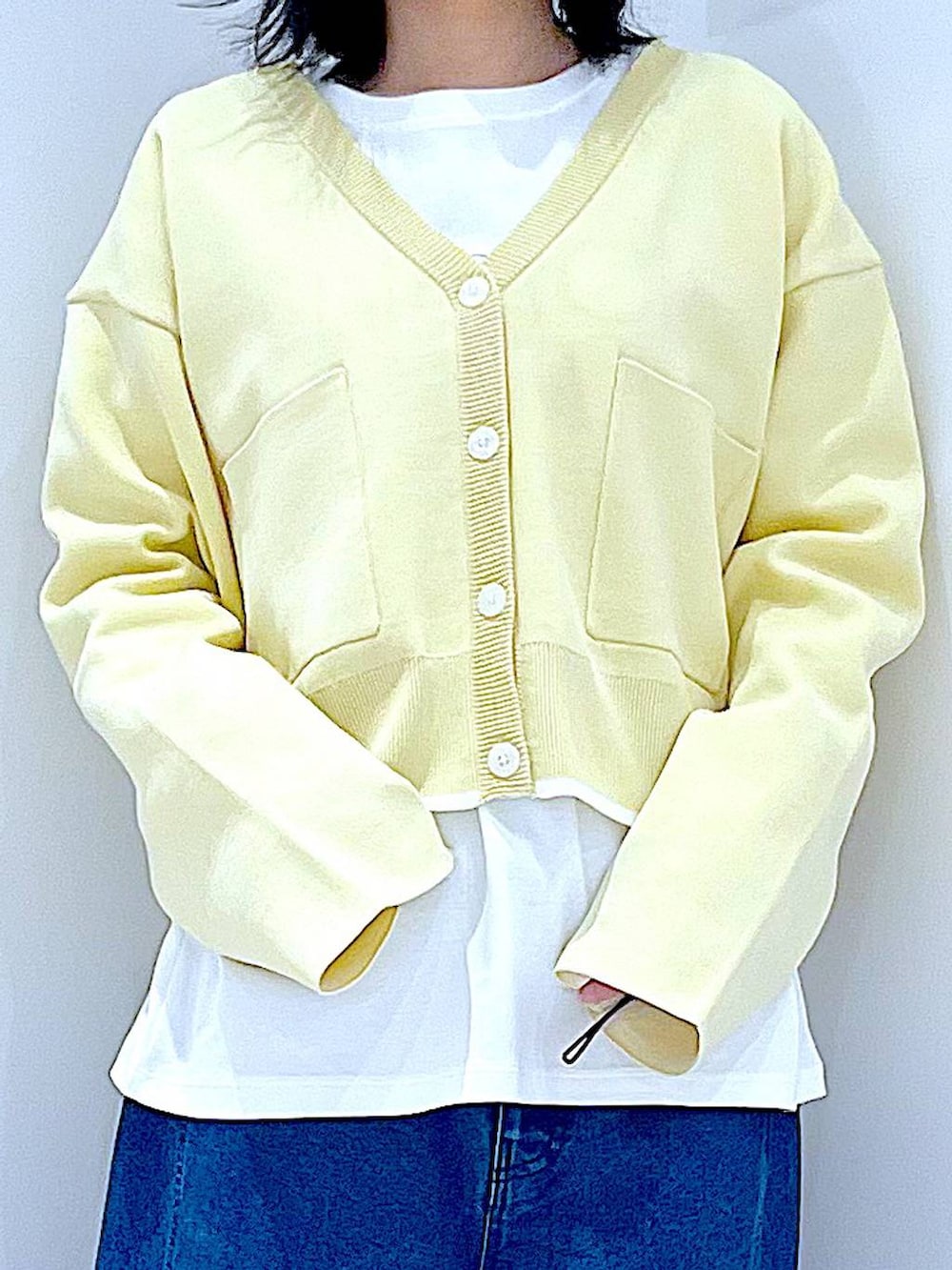 ホワイト系のショルダーバッグ、ホワイト系のTシャツ/カットソー、ブルー系のデニムパンツを着用したレディースの春コーディネートの7枚目の写真