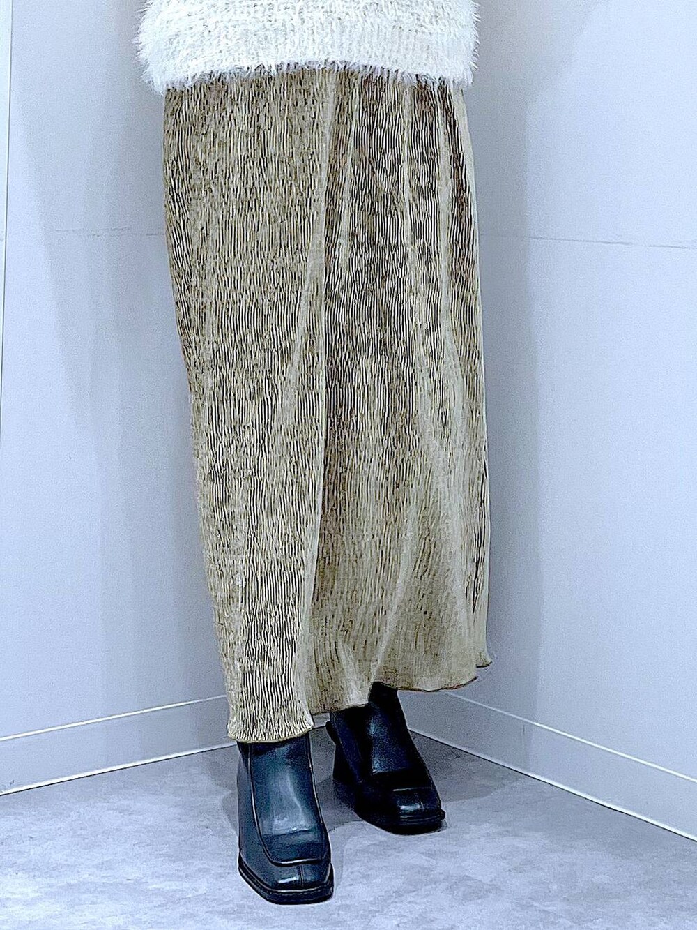 ベージュ系のハンドバッグ、ブラック系のブーツ、ベージュ系のニット/セーターを着用したレディースの冬コーディネートの8枚目の写真