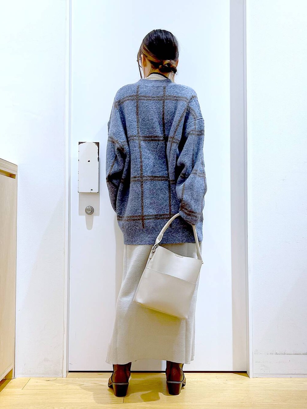 ブルー系のカーディガン/ボレロ、グレー系のショルダーバッグ、グレー系のスカートを着用したレディースの冬コーディネートの5枚目の写真