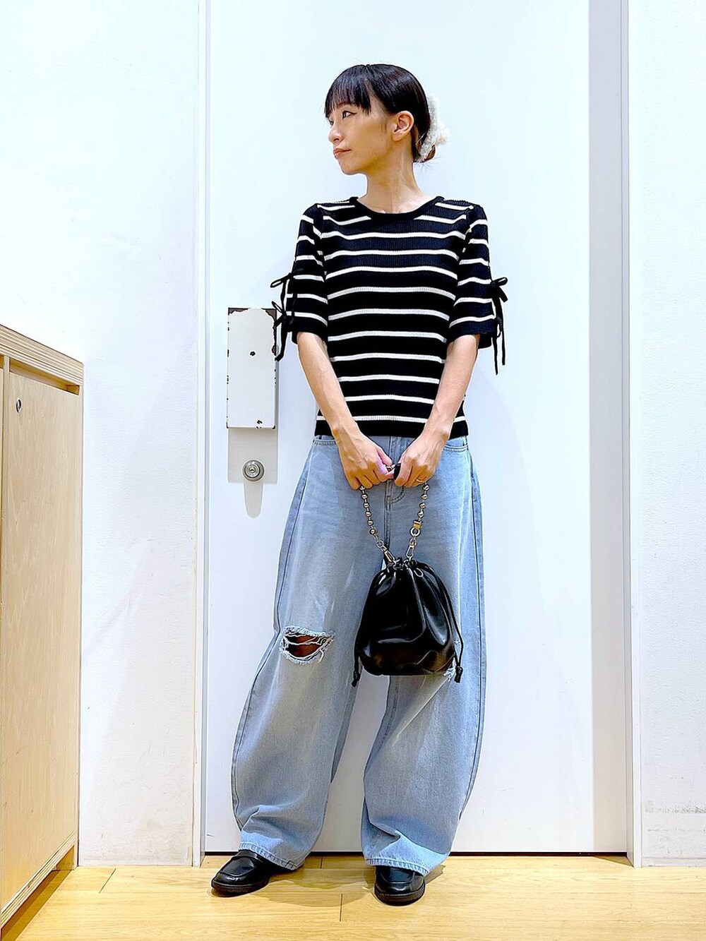 ブラック系のショルダーバッグ、ブラック系のローファー、ブラック系のニット/セーターを着用したレディースの秋コーディネートの2枚目の写真