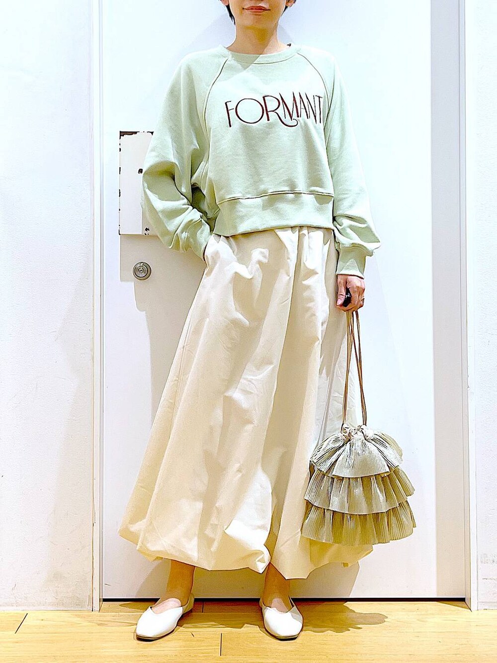 ホワイト系のパンプス、ベージュ系のショルダーバッグ、グリーン系のスウェットを着用したレディースの春コーディネートの6枚目の写真