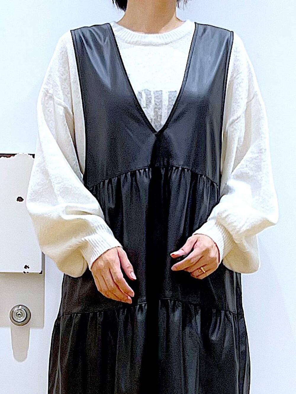 ブラック系のブーツ、ブラック系のワンピース、ピンク系のトートバッグを着用したレディースの冬コーディネートの7枚目の写真