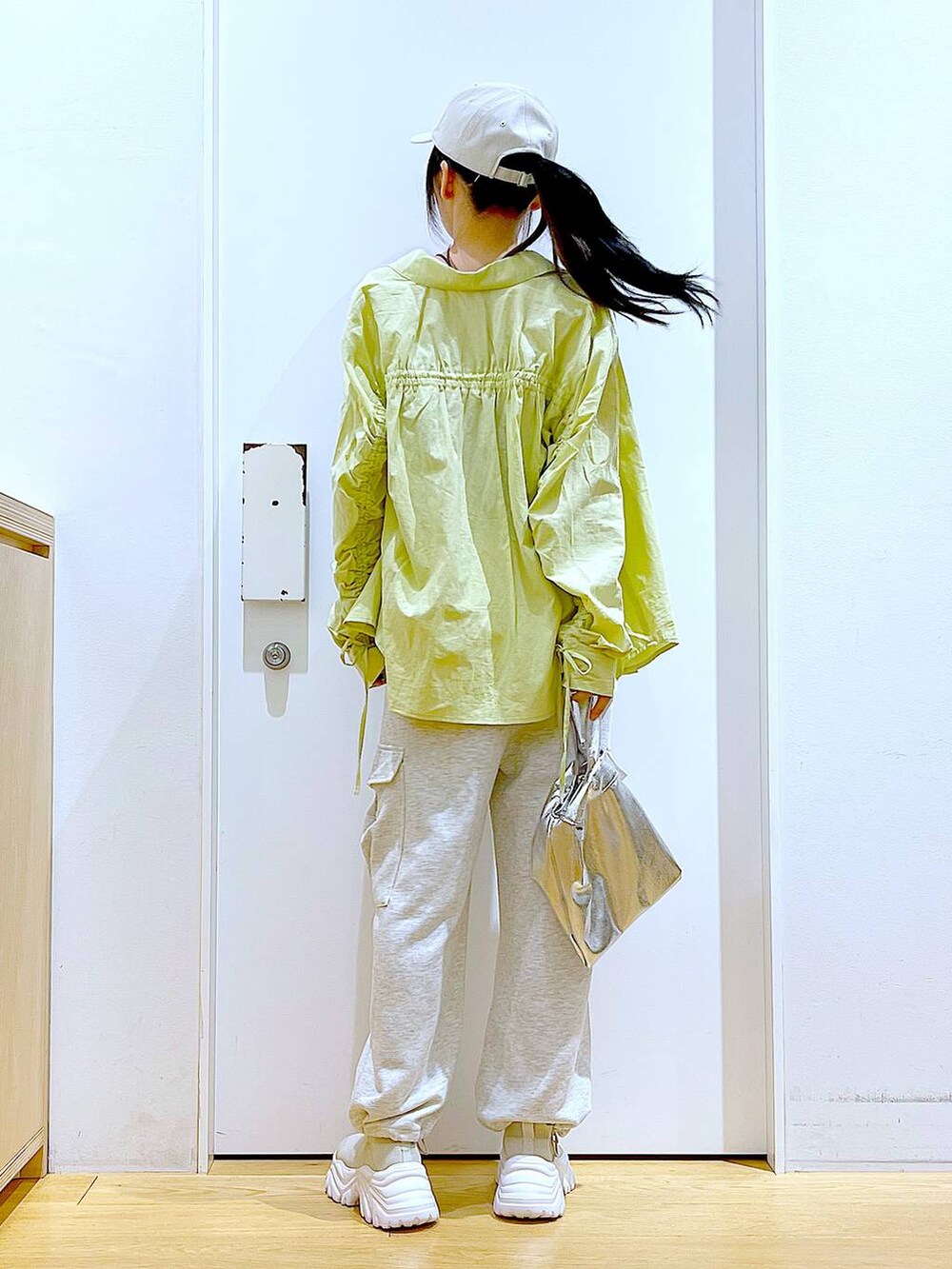 シルバー系のショルダーバッグ、ベージュ系のスウェットパンツ、グリーン系のシャツ/ブラウスを着用したレディースの春コーディネートの5枚目の写真