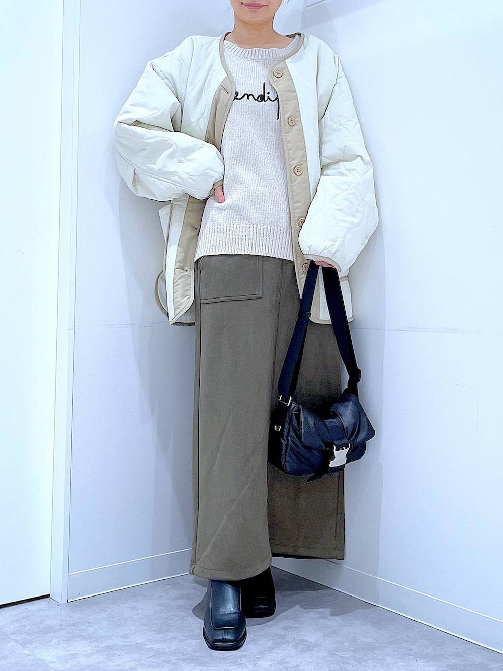 ベージュ系のブルゾン、ブラック系のブーツ、ベージュ系のニット/セーターを着用したレディースの冬コーディネートの6枚目の写真