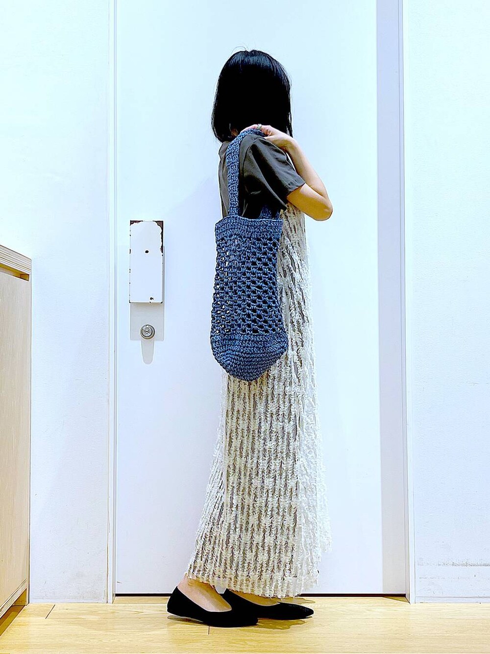 ベージュ系のワンピース、ブラック系のパンプス、ブルー系のトートバッグを着用したレディースの夏コーディネートの4枚目の写真