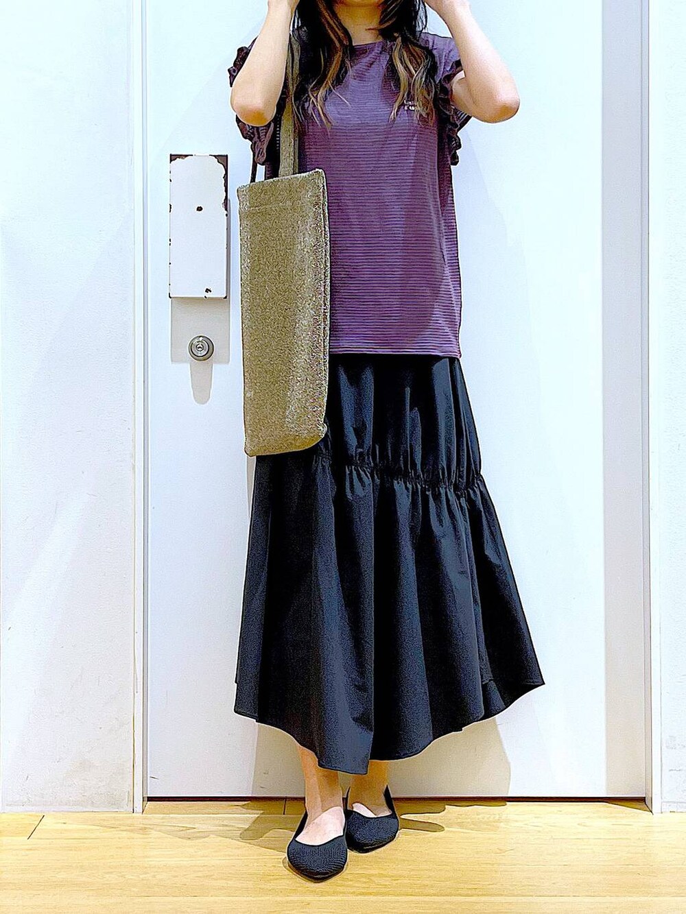 ブラック系のパンプス、ブラウン系のTシャツ/カットソー、ブラック系のスカートを着用したレディースの夏コーディネートの6枚目の写真