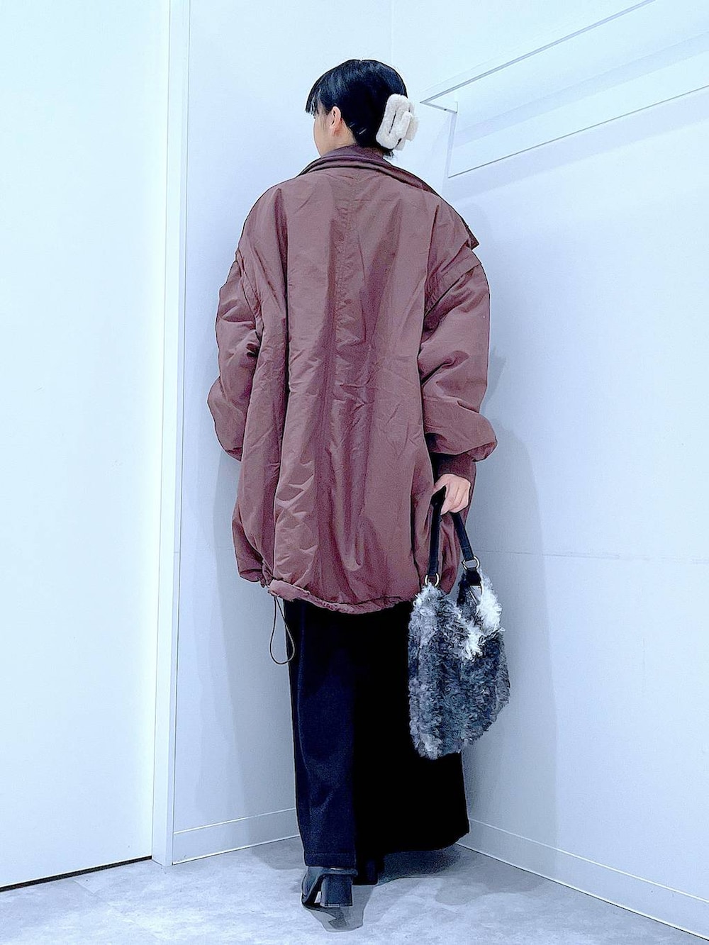 ブラウン系のブルゾン、ブラック系のブーツ、ブラック系のショルダーバッグを着用したレディースの冬コーディネートの5枚目の写真