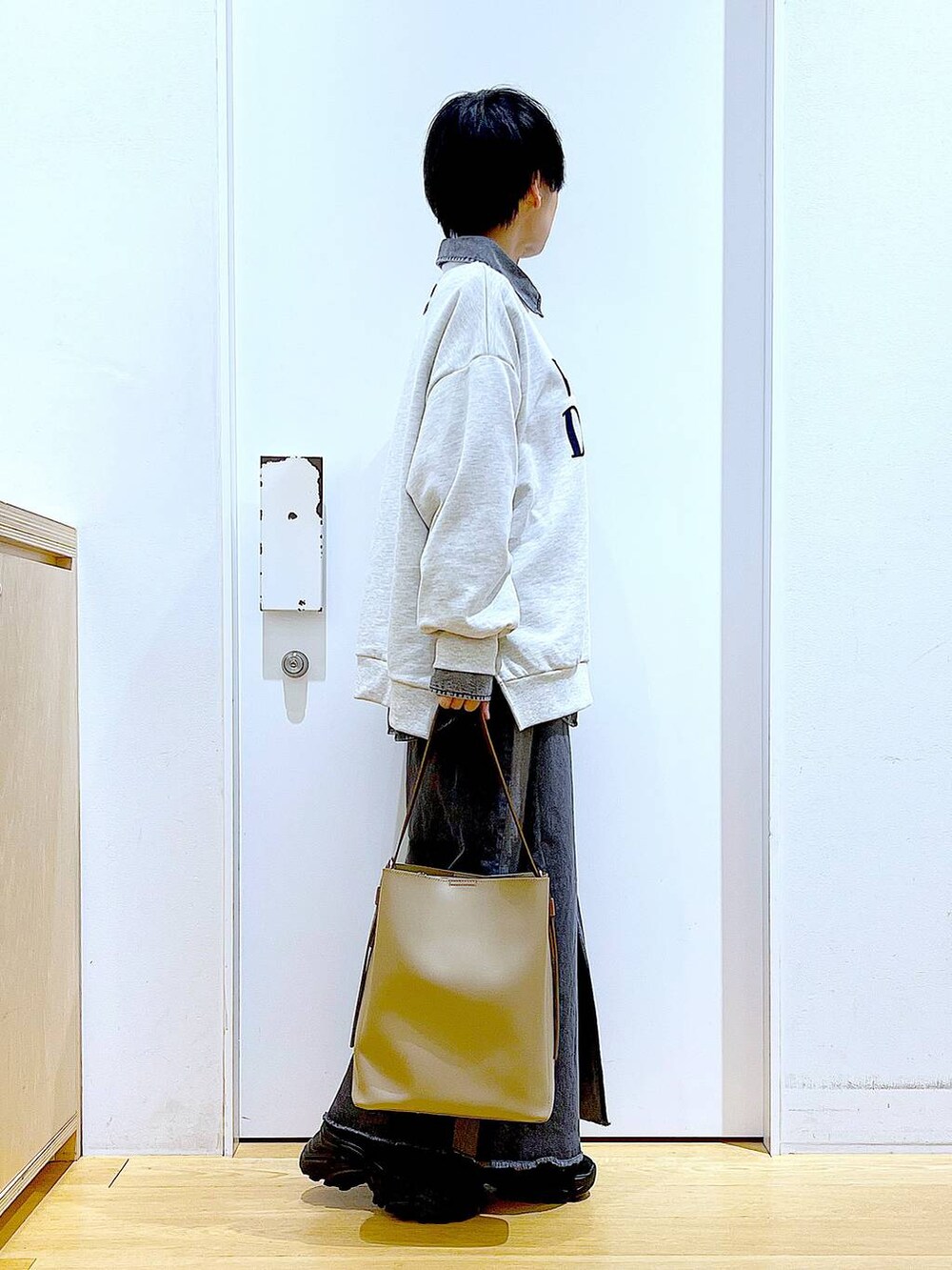 ブラック系のブーツ、グレー系のシャツ/ブラウス、ベージュ系のショルダーバッグを着用したレディースの春コーディネートの4枚目の写真