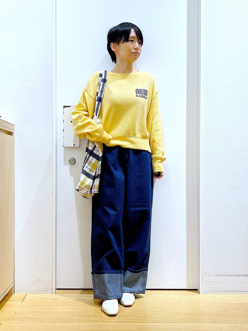 ホワイト系のパンプス、ブルー系のデニムパンツ、その他のトートバッグを着用したレディースの冬コーディネートの2枚目の写真