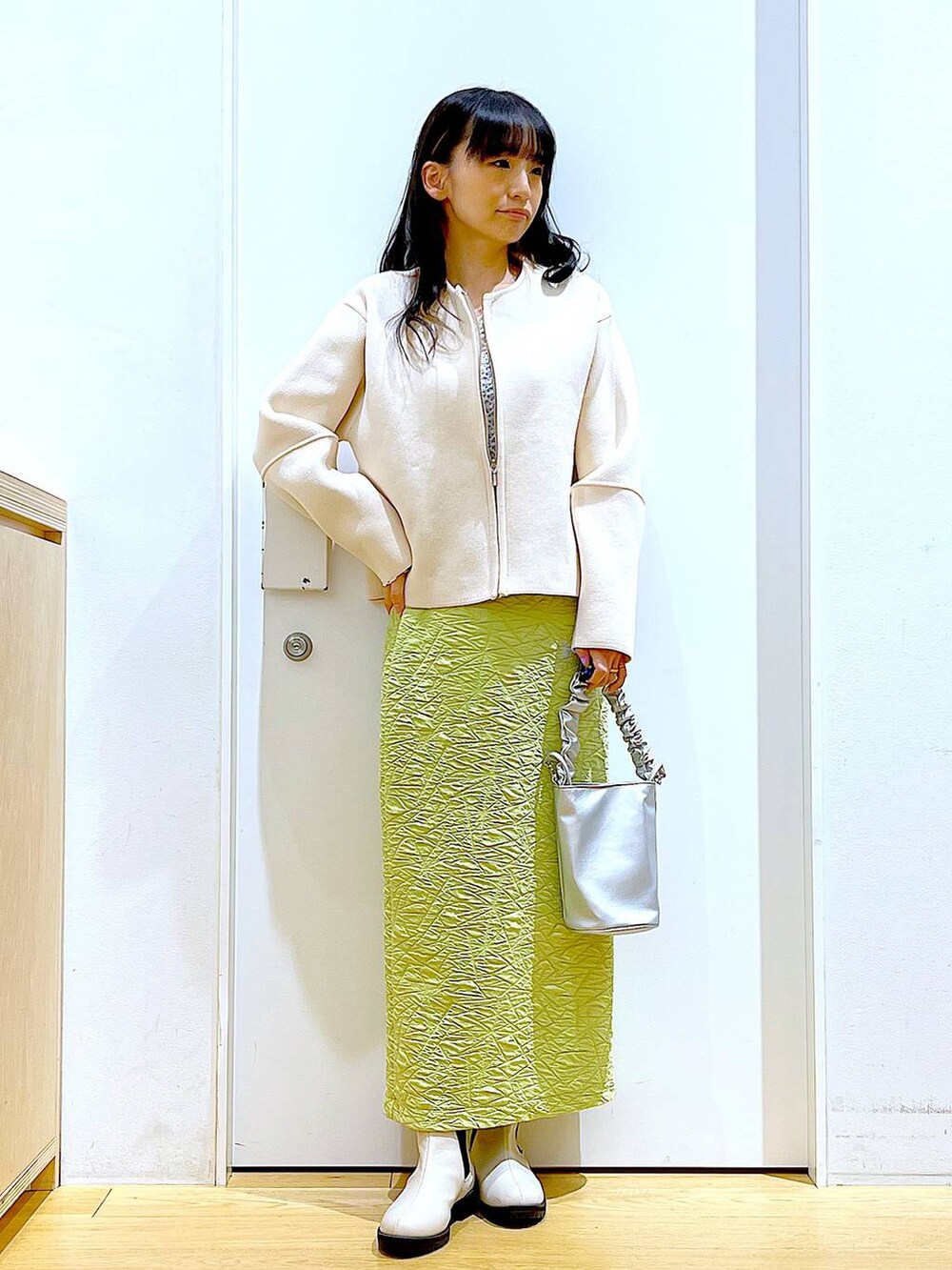 その他のショルダーバッグ、グリーン系のスカート、ベージュ系のブーツを着用したレディースの春コーディネートの2枚目の写真