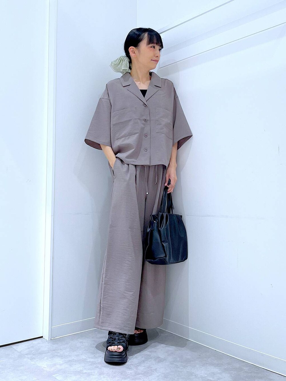 ブラック系のサンダル、ブラウン系のその他パンツ、ブラウン系のシャツ/ブラウスを着用したレディースの夏コーディネートの2枚目の写真