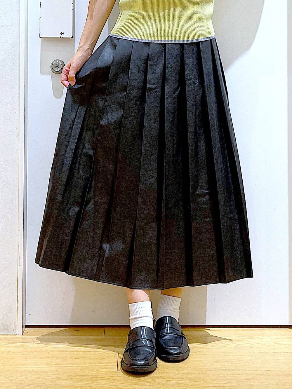 グレー系のショルダーバッグ、ブラック系のローファー、イエロー系のニット/セーターを着用したレディースの秋コーディネートの8枚目の写真