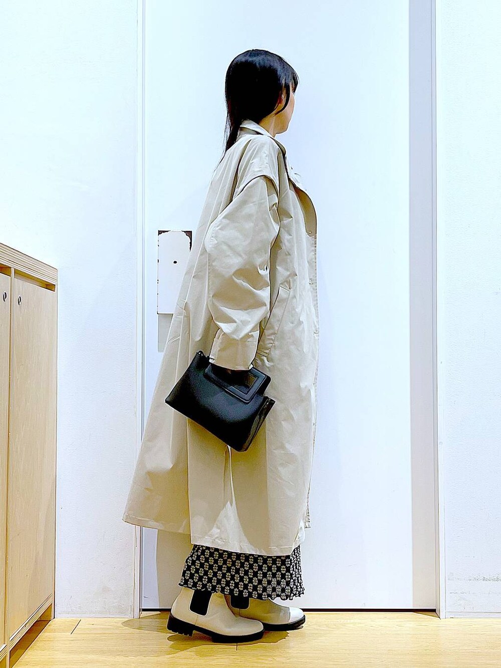 ブラック系のTシャツ/カットソー、ブラック系のスカート、ベージュ系のブーツを着用したレディースの春コーディネートの4枚目の写真