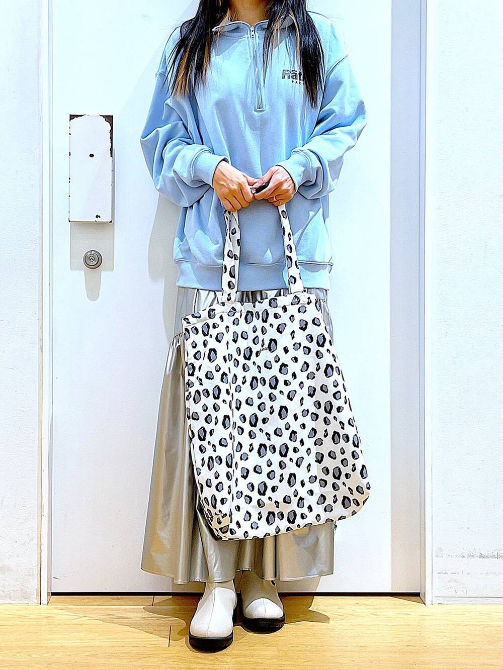 ブルー系のスウェット、シルバー系のスカート、ベージュ系のブーツを着用したレディースの春コーディネートの6枚目の写真
