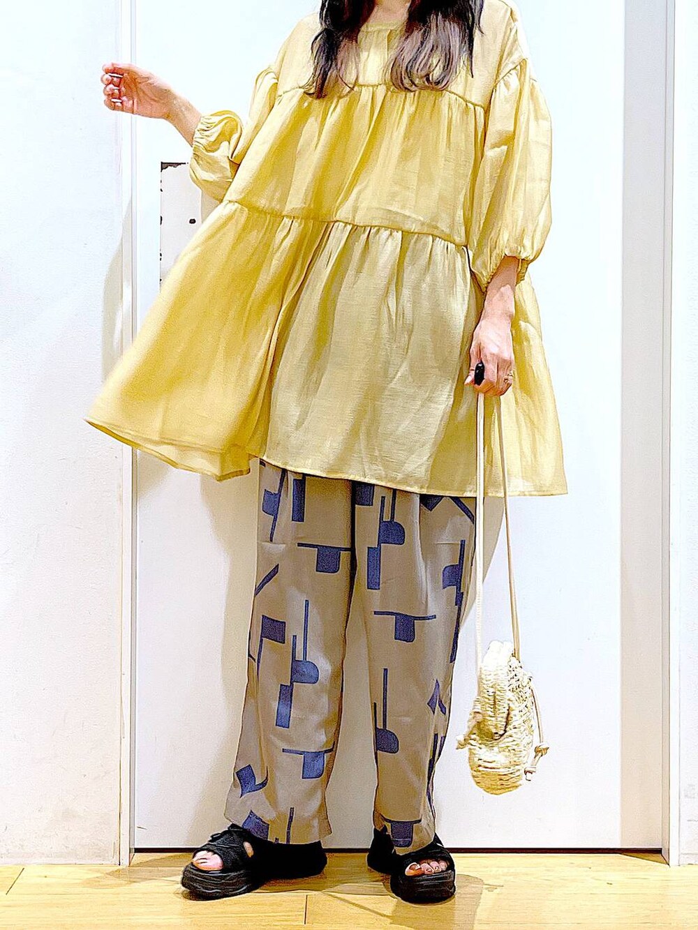 グレー系のその他パンツ、ホワイト系のショルダーバッグ、ブラック系のサンダルを着用したレディースの夏コーディネートの6枚目の写真