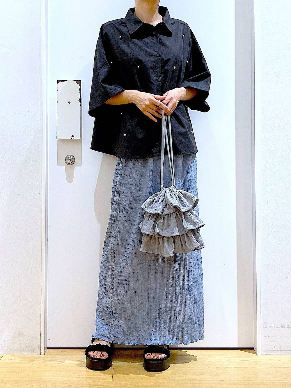 ブラック系のサンダル、ブルー系のスカート、グレー系のショルダーバッグを着用したレディースの秋コーディネートの6枚目の写真