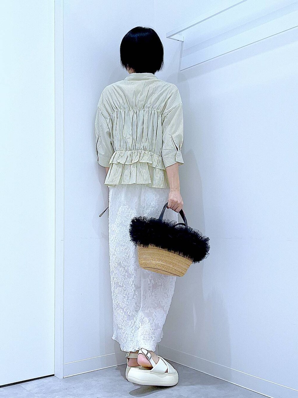 ベージュ系のショルダーバッグ、ホワイト系のサンダル、ホワイト系のスカートを着用したレディースの夏コーディネートの5枚目の写真