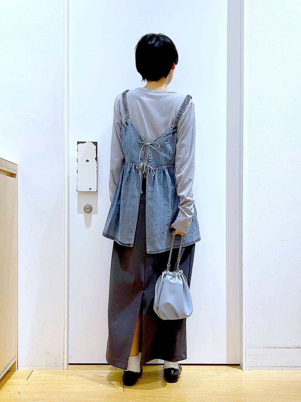 ブルー系のショルダーバッグ、ブラック系のパンプス、ブルー系のその他トップスを着用したレディースの春コーディネートの5枚目の写真