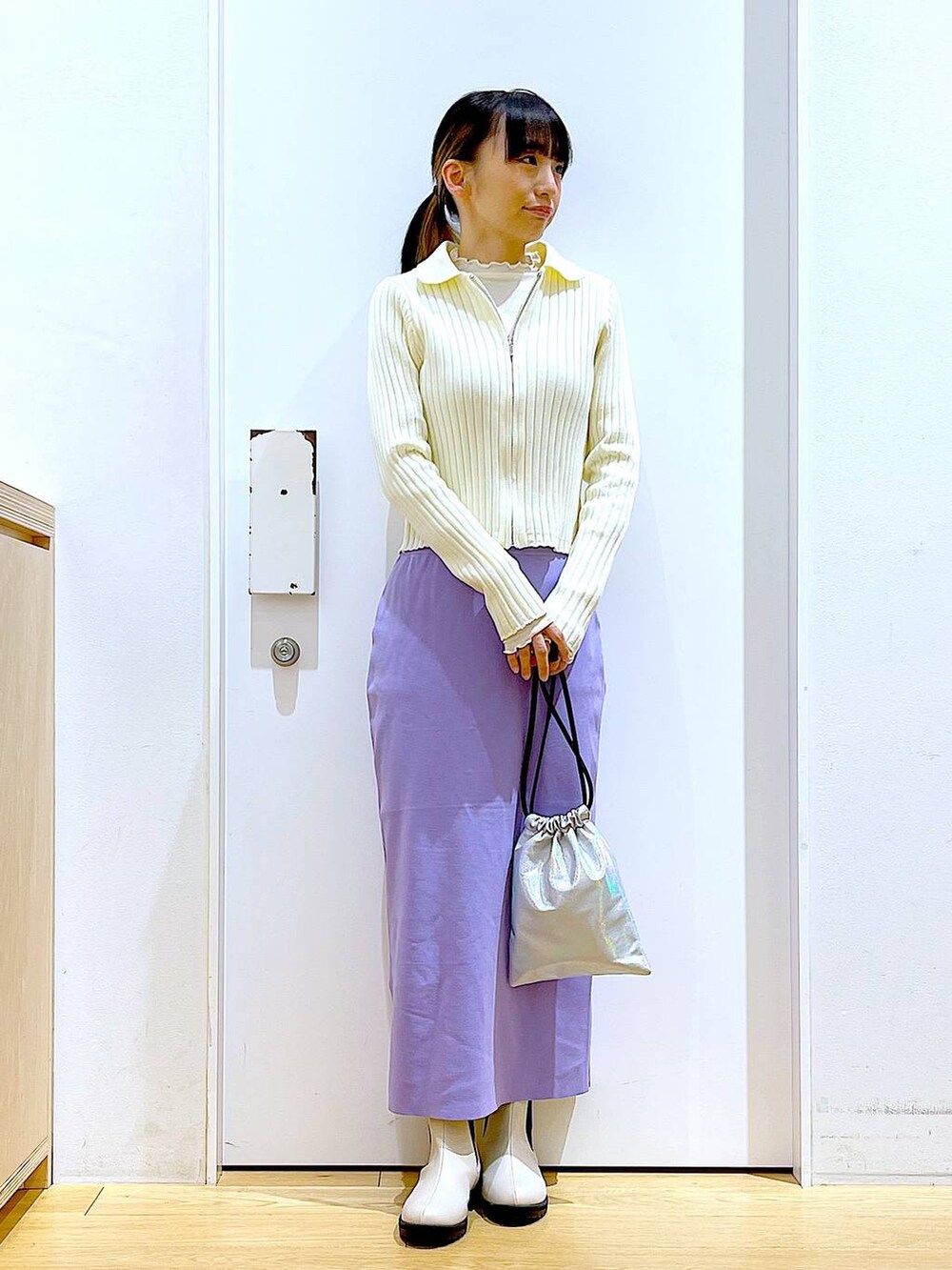 ホワイト系のTシャツ/カットソー、ベージュ系のカーディガン/ボレロ、ベージュ系のブーツを着用したレディースの春コーディネートの2枚目の写真