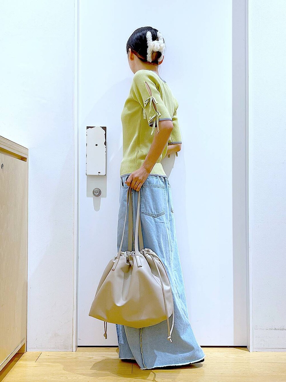 ベージュ系のトートバッグ、シルバー系のローファー、イエロー系のニット/セーターを着用したレディースの秋コーディネートの3枚目の写真