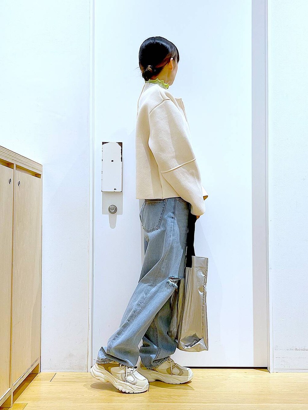 グリーン系のTシャツ/カットソー、ベージュ系のスニーカー、ブルー系のデニムパンツを着用したレディースの冬コーディネートの4枚目の写真