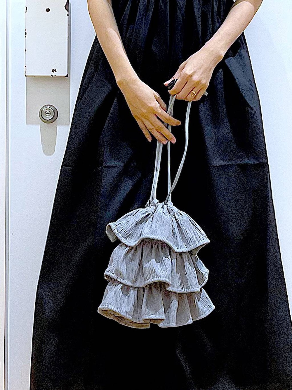 ホワイト系のサンダル、ベージュ系のTシャツ/カットソー、ブラック系のワンピースを着用したレディースの夏コーディネートの9枚目の写真