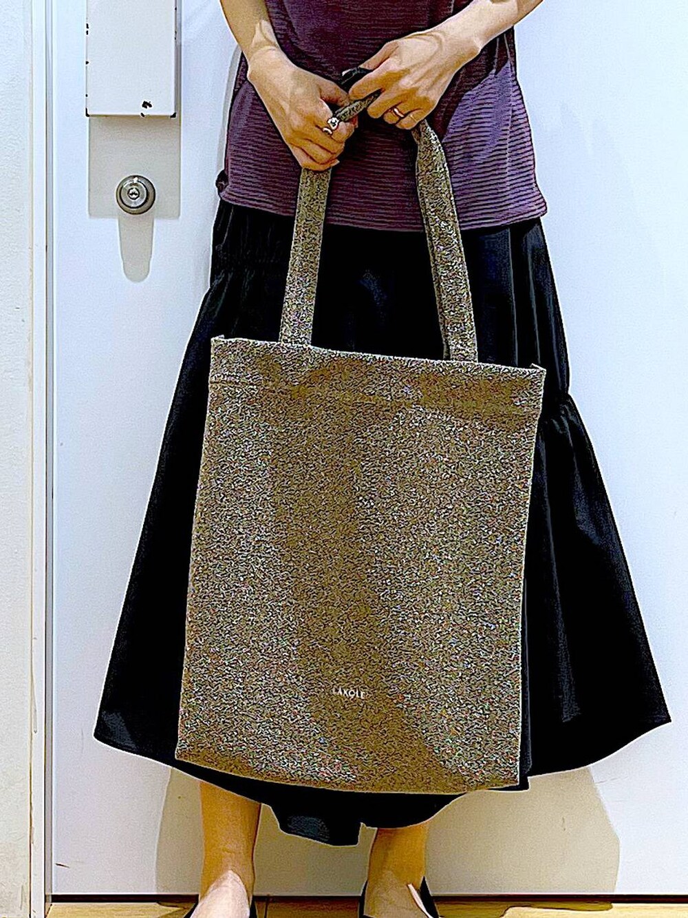 ブラック系のパンプス、ブラウン系のTシャツ/カットソー、ブラック系のスカートを着用したレディースの夏コーディネートの9枚目の写真