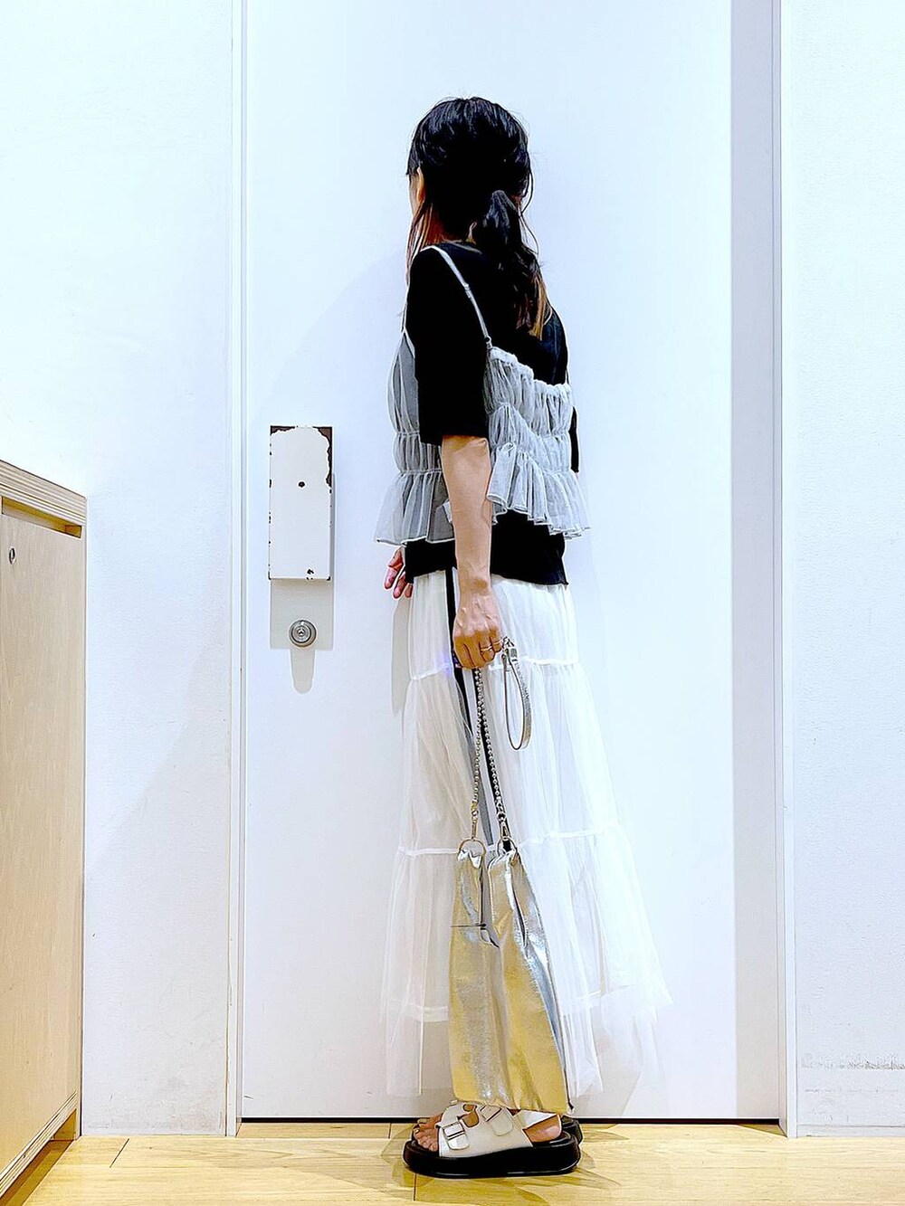 シルバー系のショルダーバッグ、ホワイト系のサンダル、ホワイト系のキャミソールを着用したレディースの夏コーディネートの3枚目の写真
