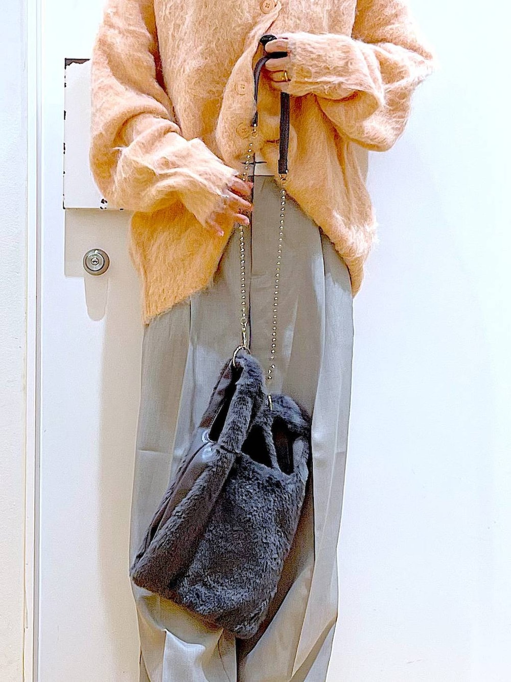 ピンク系のカーディガン/ボレロ、グレー系のショルダーバッグ、ベージュ系のブーツを着用したレディースの冬コーディネートの9枚目の写真